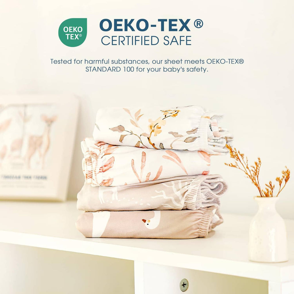 Stack of fitted bassinet sheets with blush woodland animal and leaf print