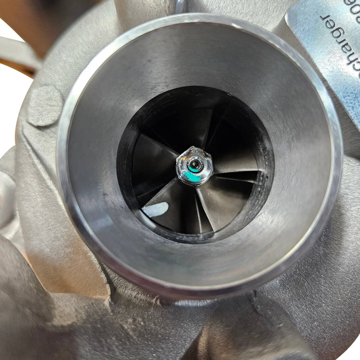 Turbocharger compressor wheel inside metal housing with central mounting bolt