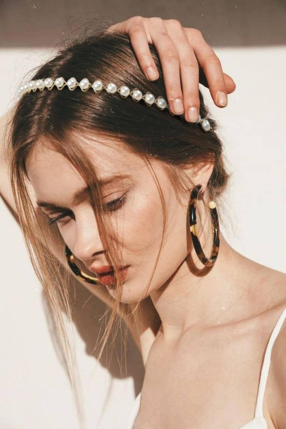 White pearl headband with bead accents, worn across the front of hair