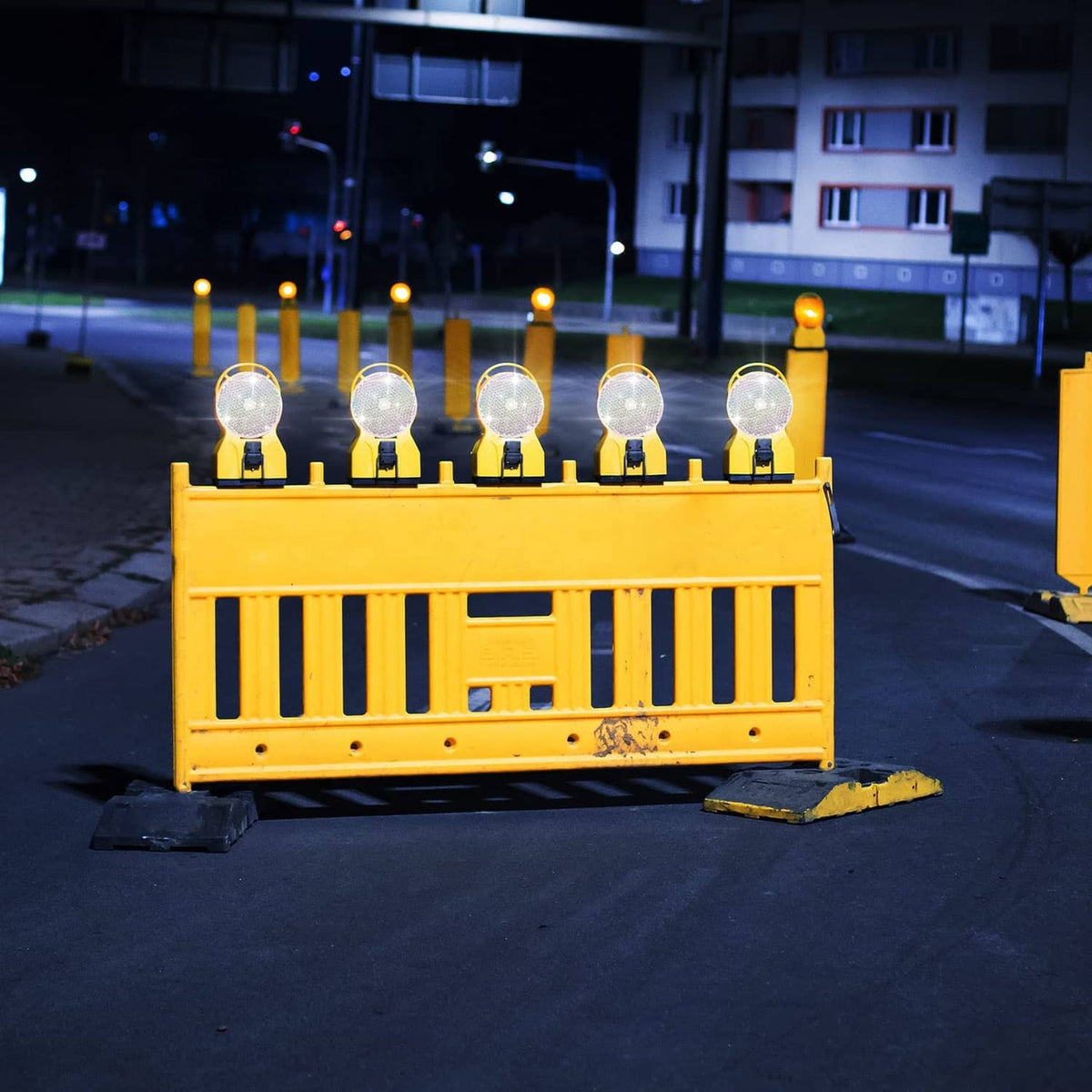 Round white reflective marker heads mounted on a roadside barrier for nighttime safety