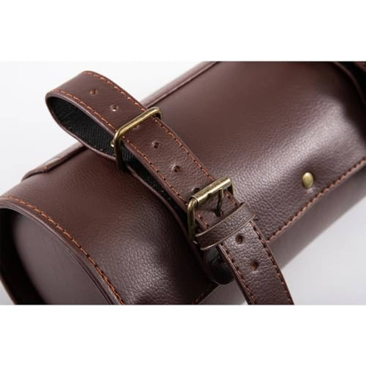 Brown motorcycle bag close-up of metal buckle strap and rivets