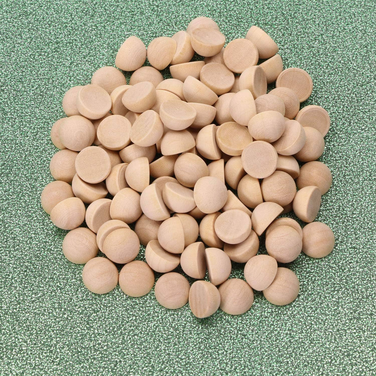 Unfinished light wood half-round balls, smooth split pieces scattered in pile