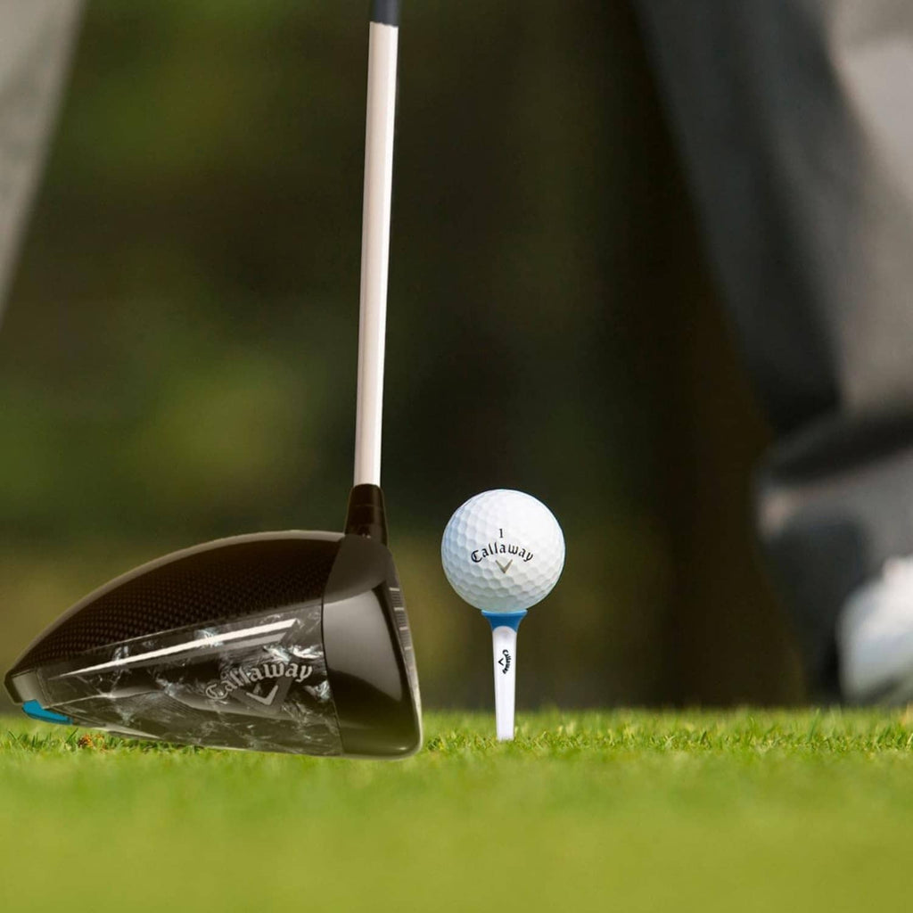 Callaway golf tee holding a white ball beside a club on the course