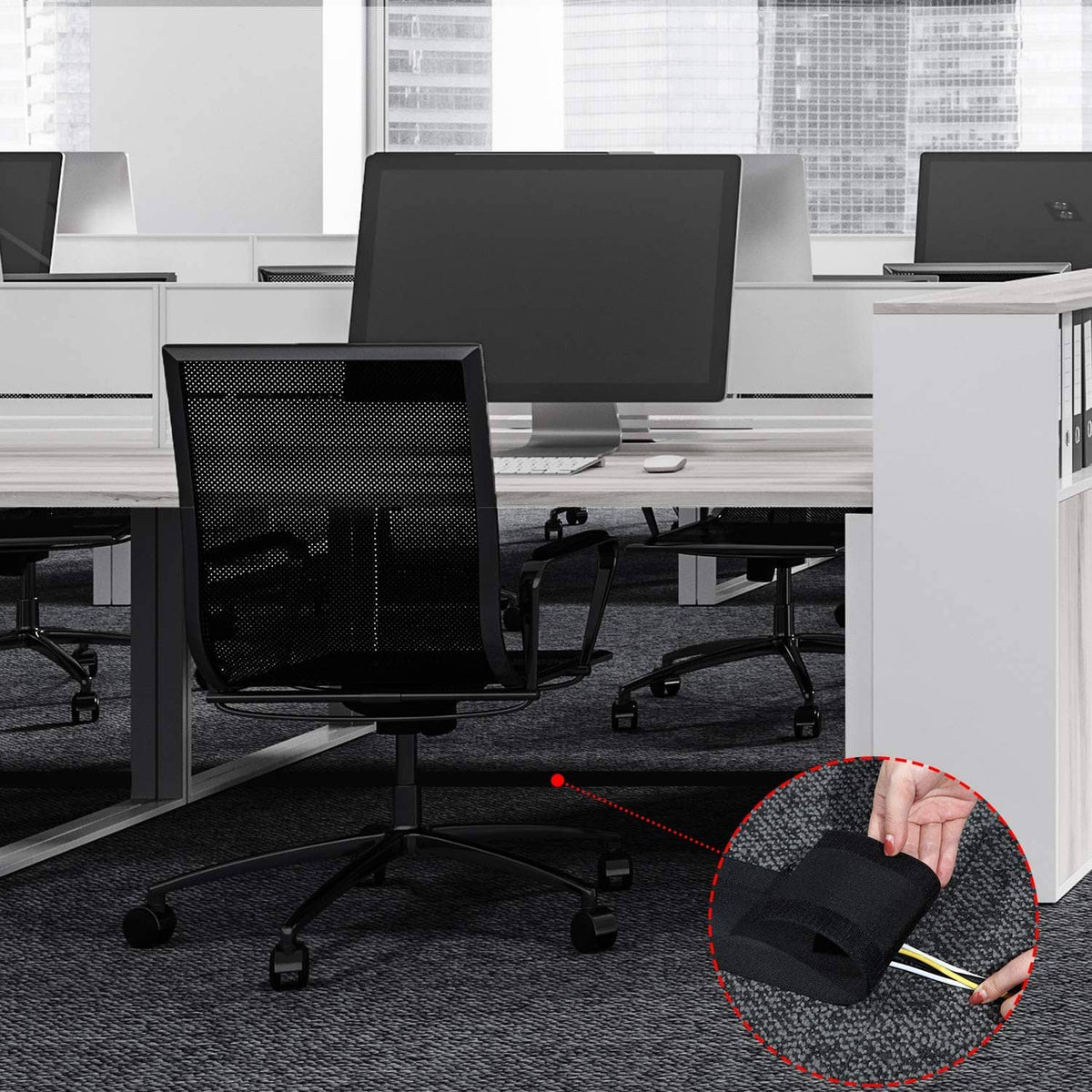 Black carpet cord cover cable protector installed on office carpet with cables routed