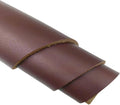 Brown vegetable-tanned leather sheet, rolled edge close-up with visible grain texture