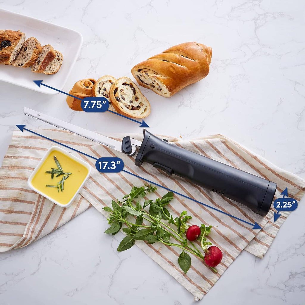 Cordless electric knife slicing bread on a towel, black handle and serrated blade