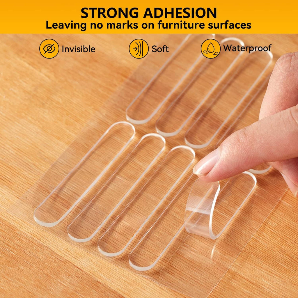 Clear self-adhesive wall bumper pads being placed on a wooden surface