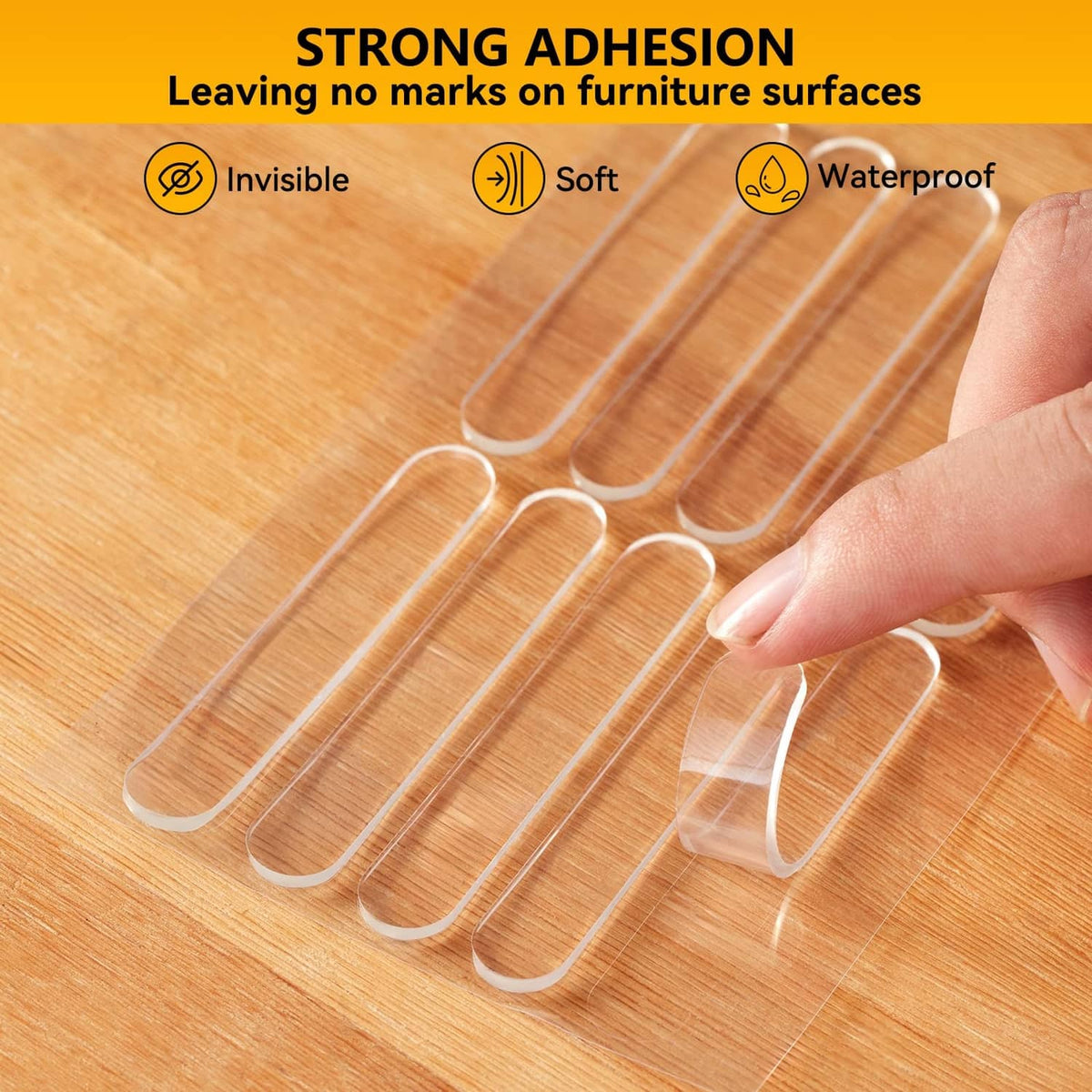 Clear self-adhesive wall bumper pads being placed on a wooden surface