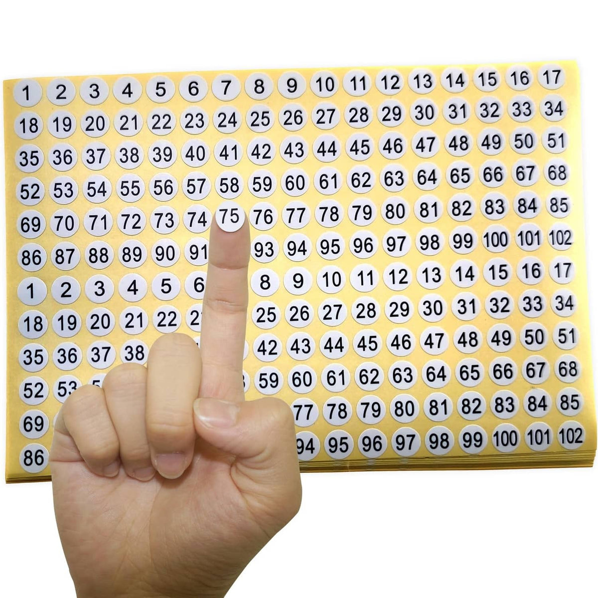Sheet of round number stickers 1–102 with white labels on yellow backing, held by a hand