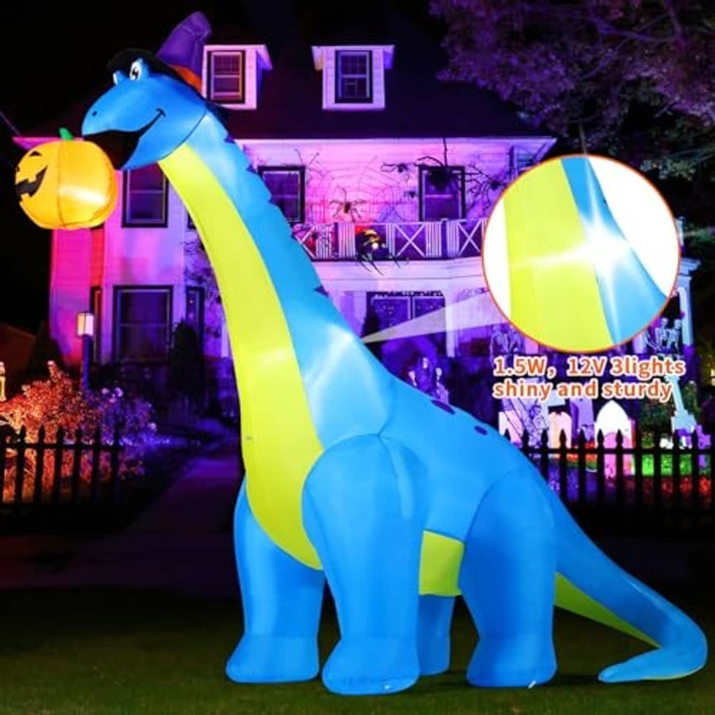 Inflatable blue dinosaur with green stripe and purple hat holding jack-o'-lantern