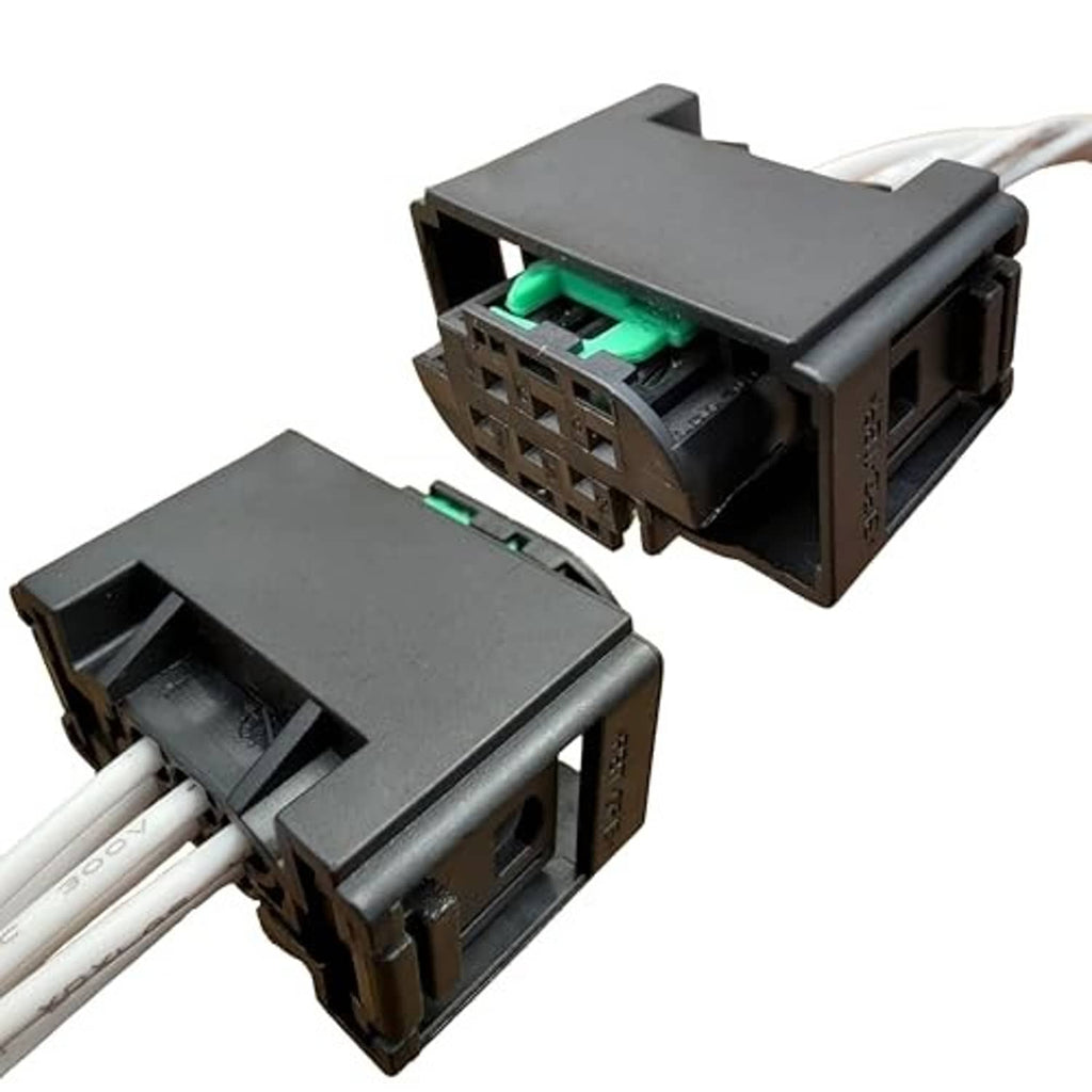 Sensor wiring harness connector with black housing, green terminals, and white wire leads