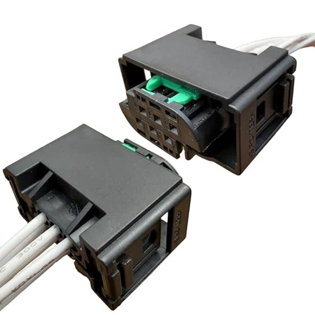 Sensor wiring harness connector with black housing, green terminals, and white wire leads