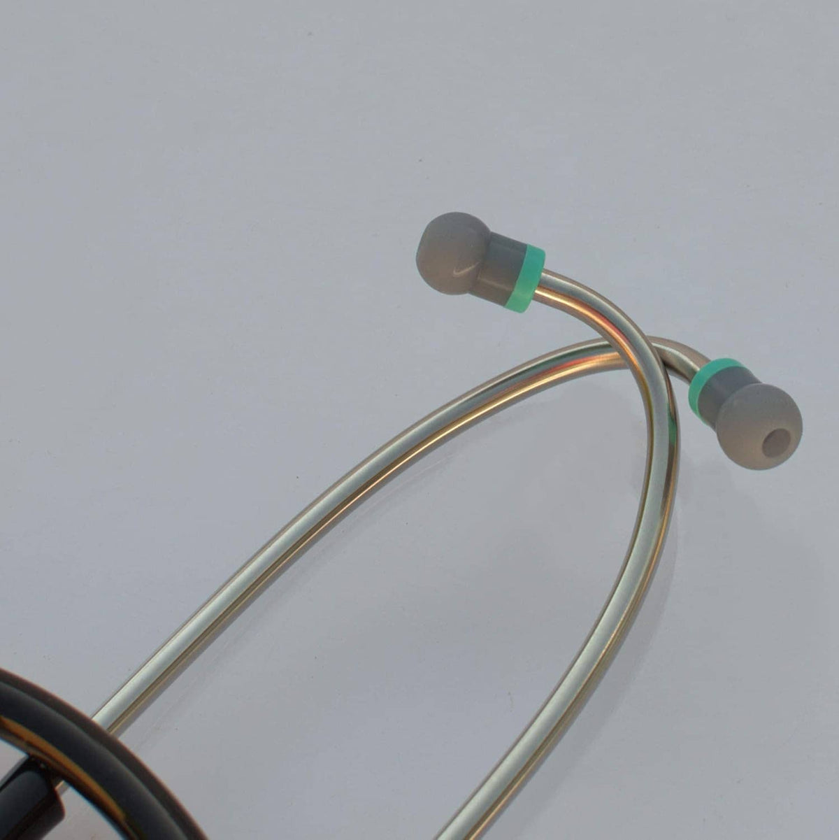 Metal stethoscope tubing with gray ear tips and teal connector sleeves