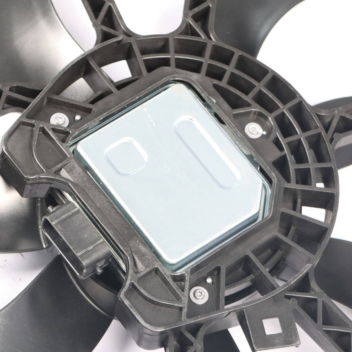 Radiator cooling fan motor cover in gray panel within black fan shroud housing