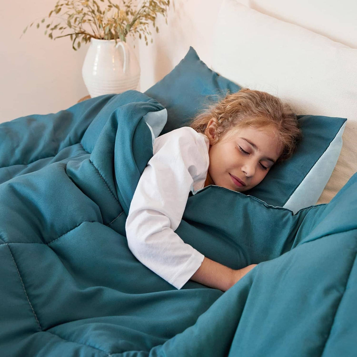King-size reversible comforter set in teal with light-blue underside, shown with person on bed