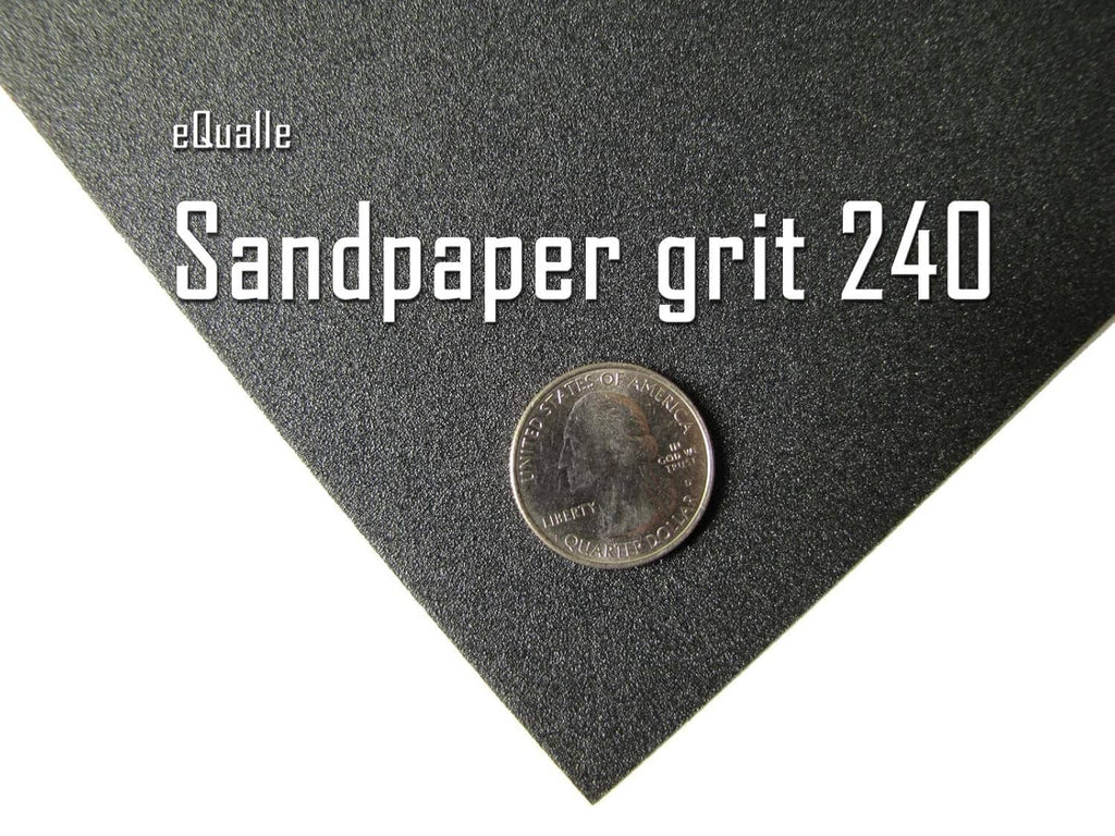 240-grit black sandpaper grit sheet with coin for scale