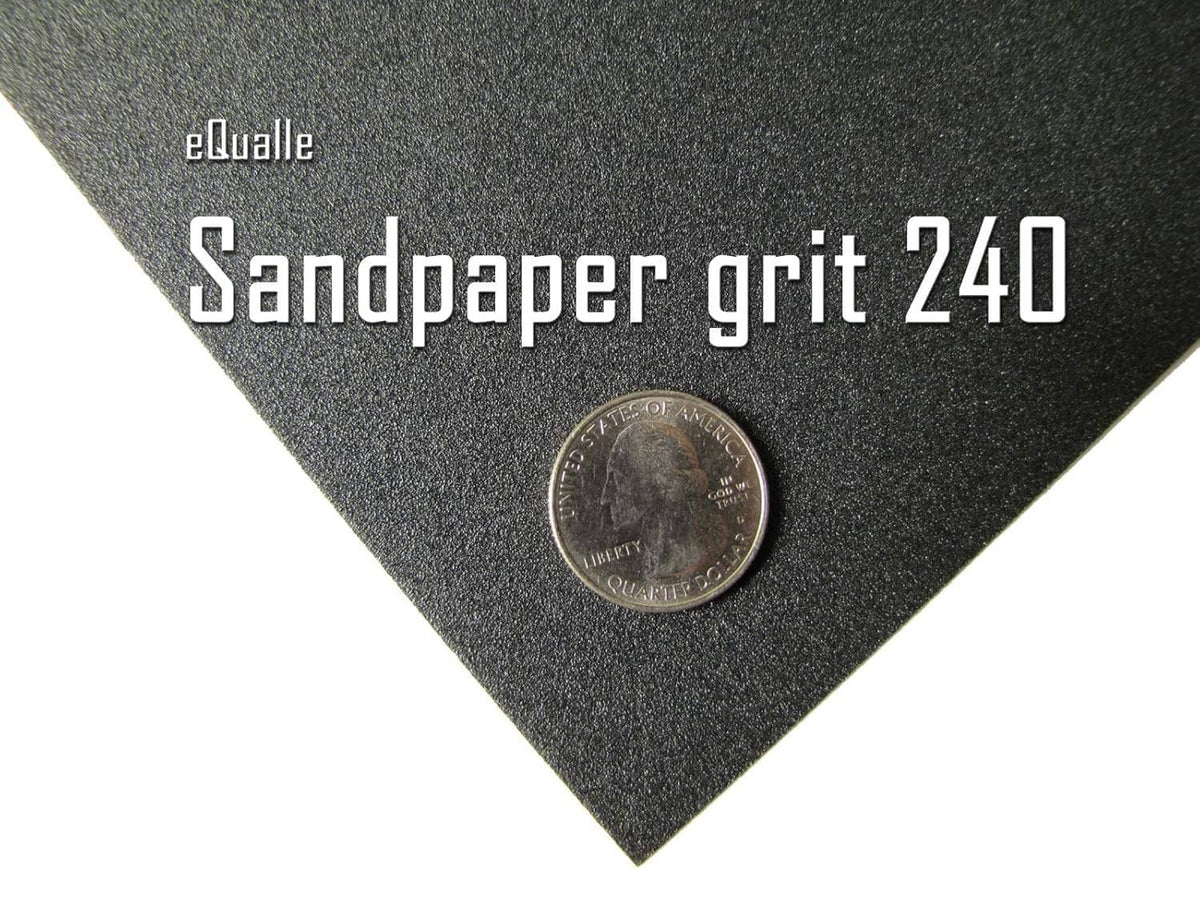 240-grit black sandpaper grit sheet with coin for scale
