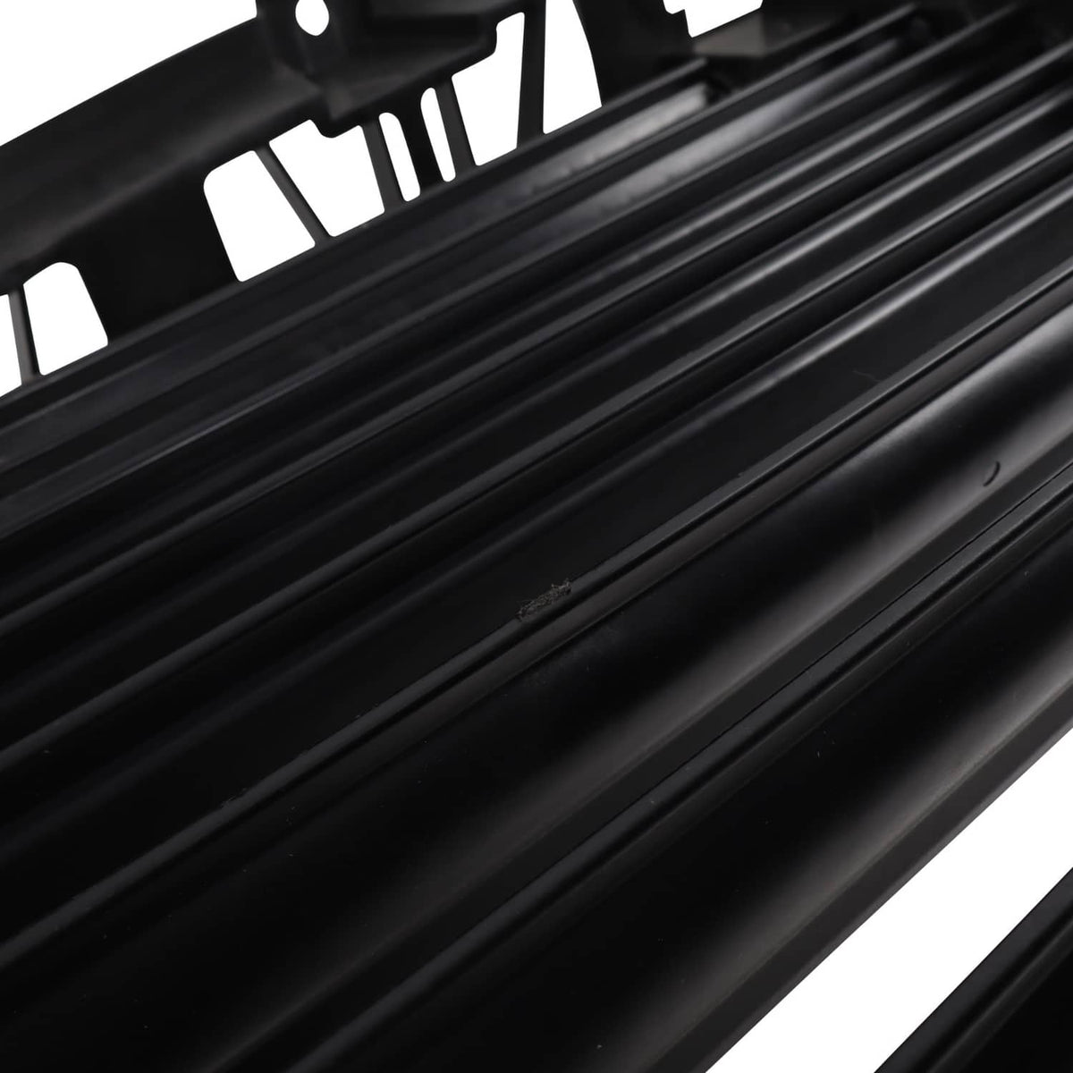 Close-up of black upper grille air shutter slats and slat frame edges