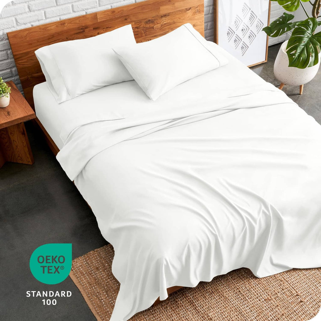 Cream bed sheet set with fitted sheet draped over the mattress on a bed