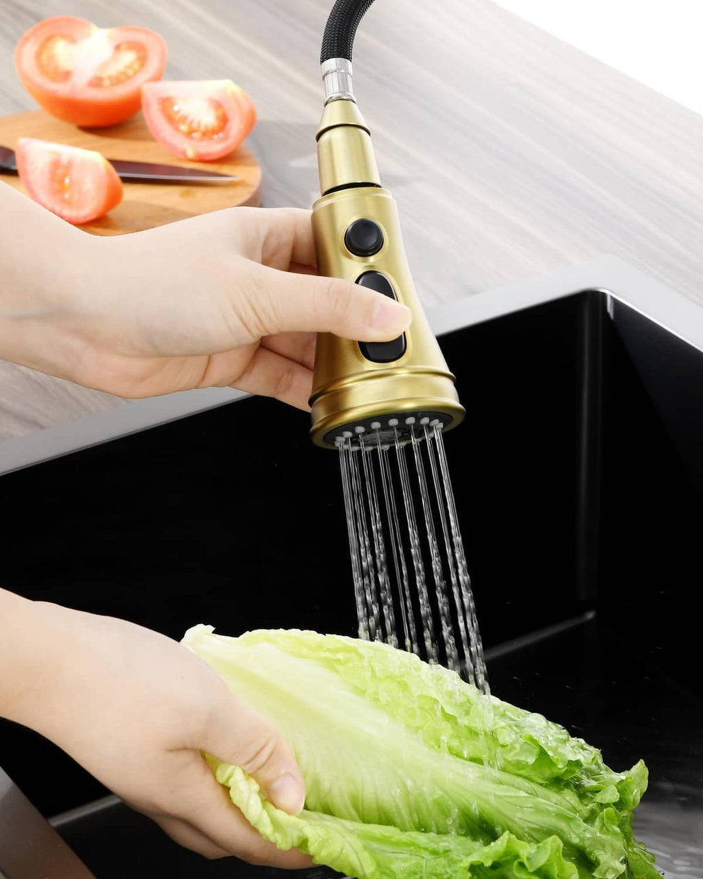 Brushed gold sprayer head rinsing leafy greens with a steady water spray