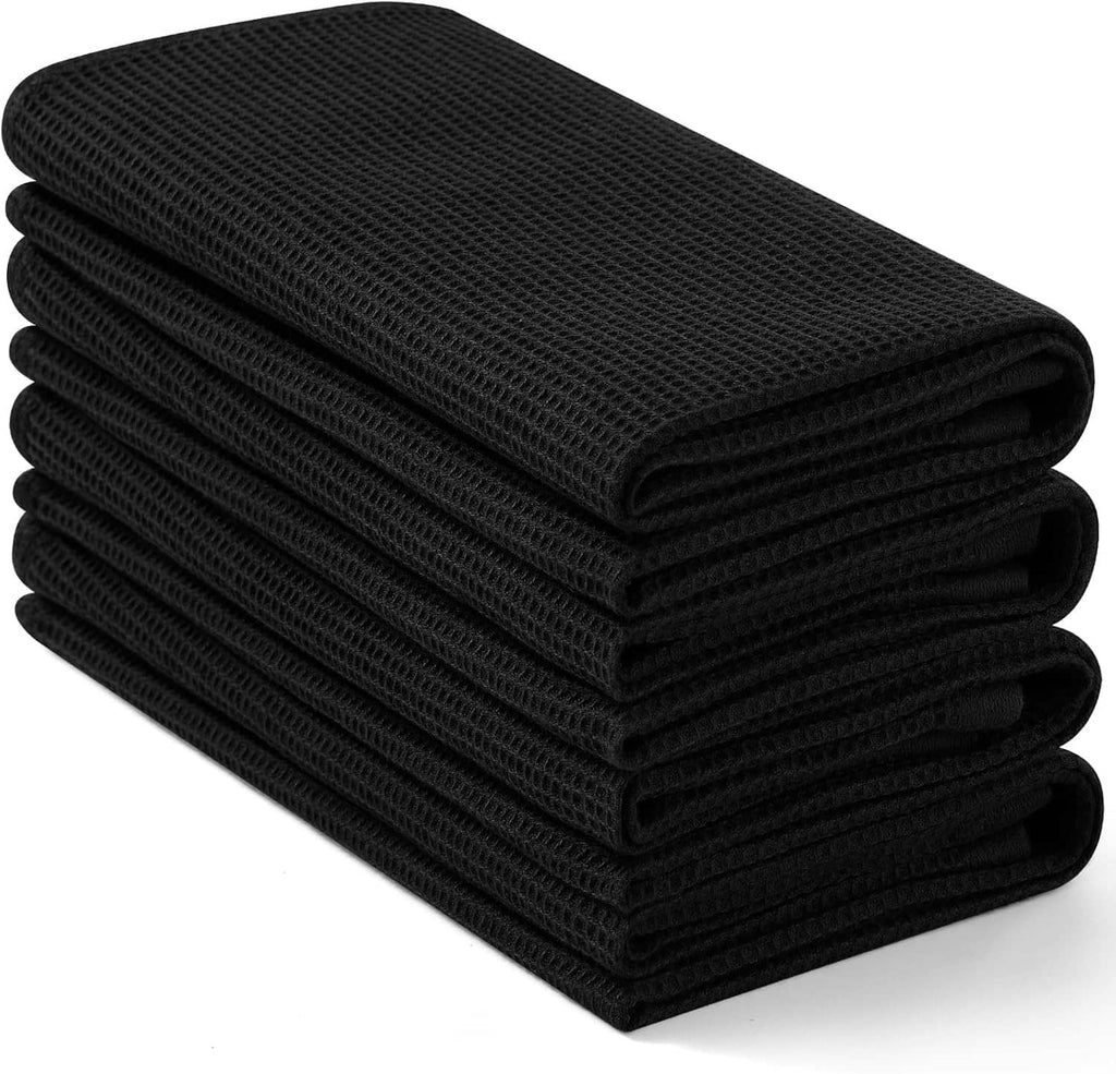 Black waffle weave cotton kitchen towels stacked, top towel folded over