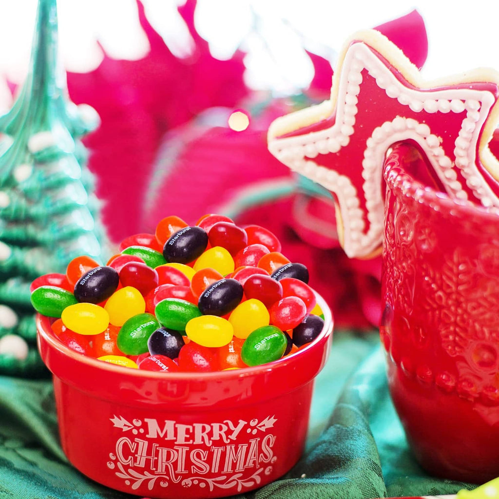 Cup of assorted colorful jelly beans with red and white star-shaped holiday decoration
