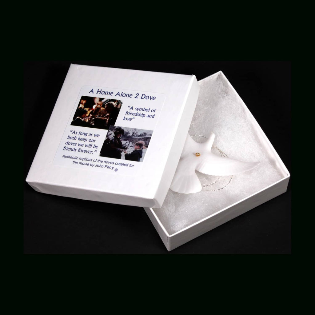 Open presentation box showing two white dove ornaments and a printed authenticity card