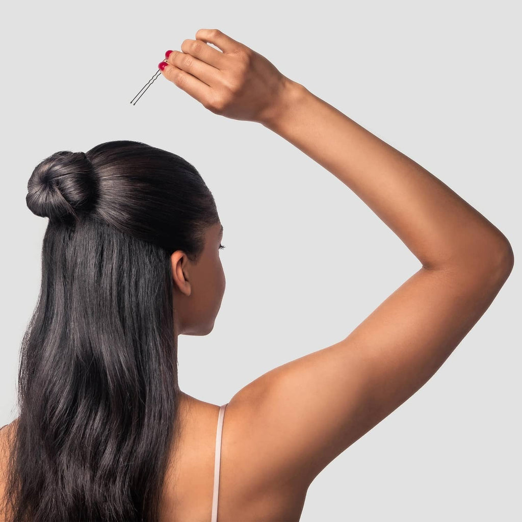 Black hair pins being inserted into a long hair bun, 3-inch extra large size
