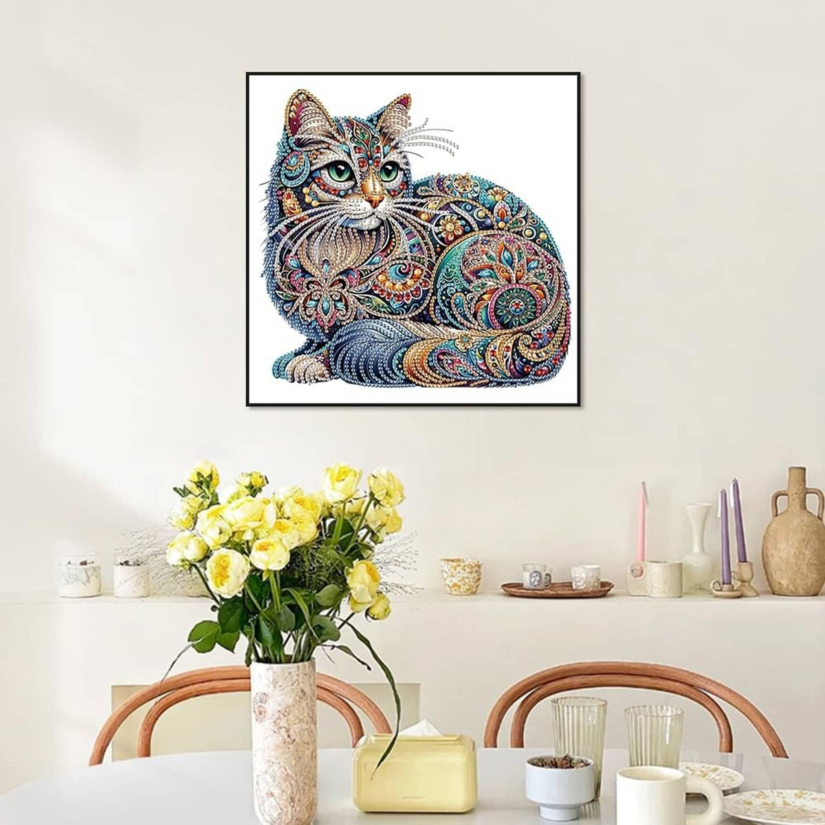 Multicolor diamond art cat picture in a wall frame above flowers and tabletop decor