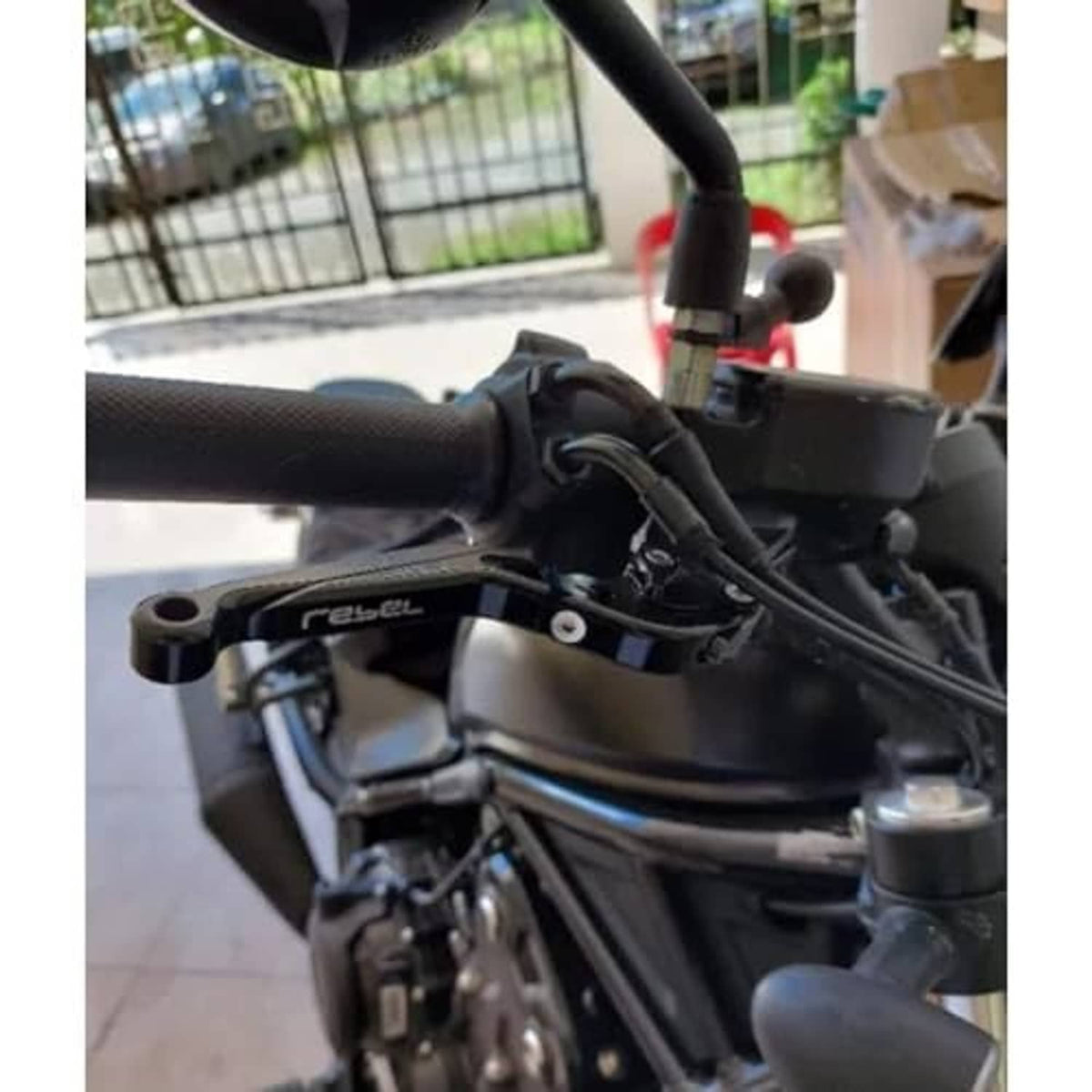 Black motorcycle brake lever installed on handlebar near controls