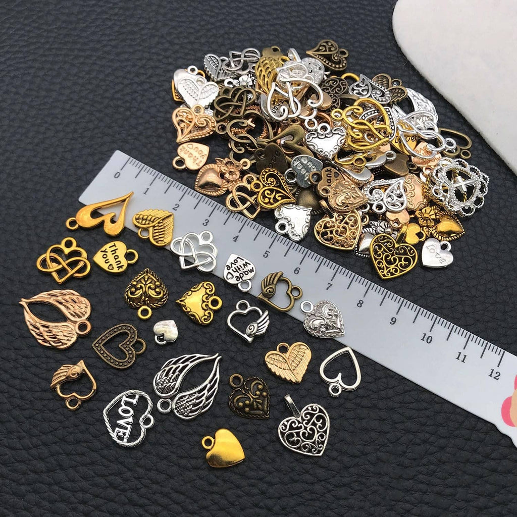 Small assorted heart charms with wings, hearts, and filigree shapes; with a measuring ruler