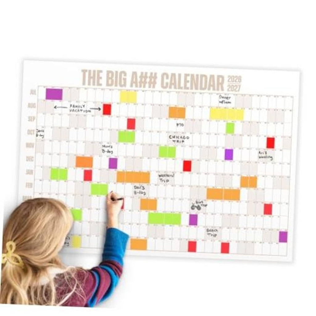 Dry-erase wall calendar with colorful blocks and labels, person writing with a marker