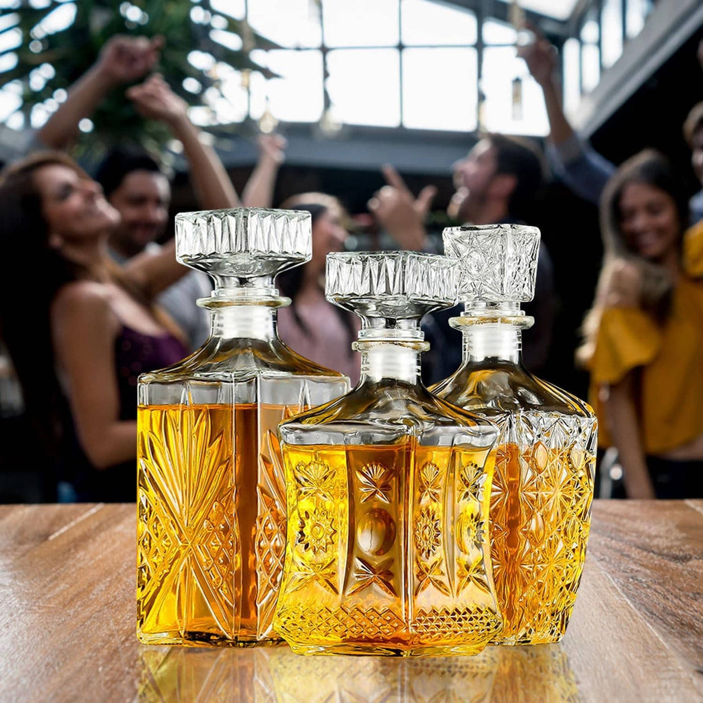 Three crystal whiskey decanters with faceted glass panels and clear, ribbed stoppers