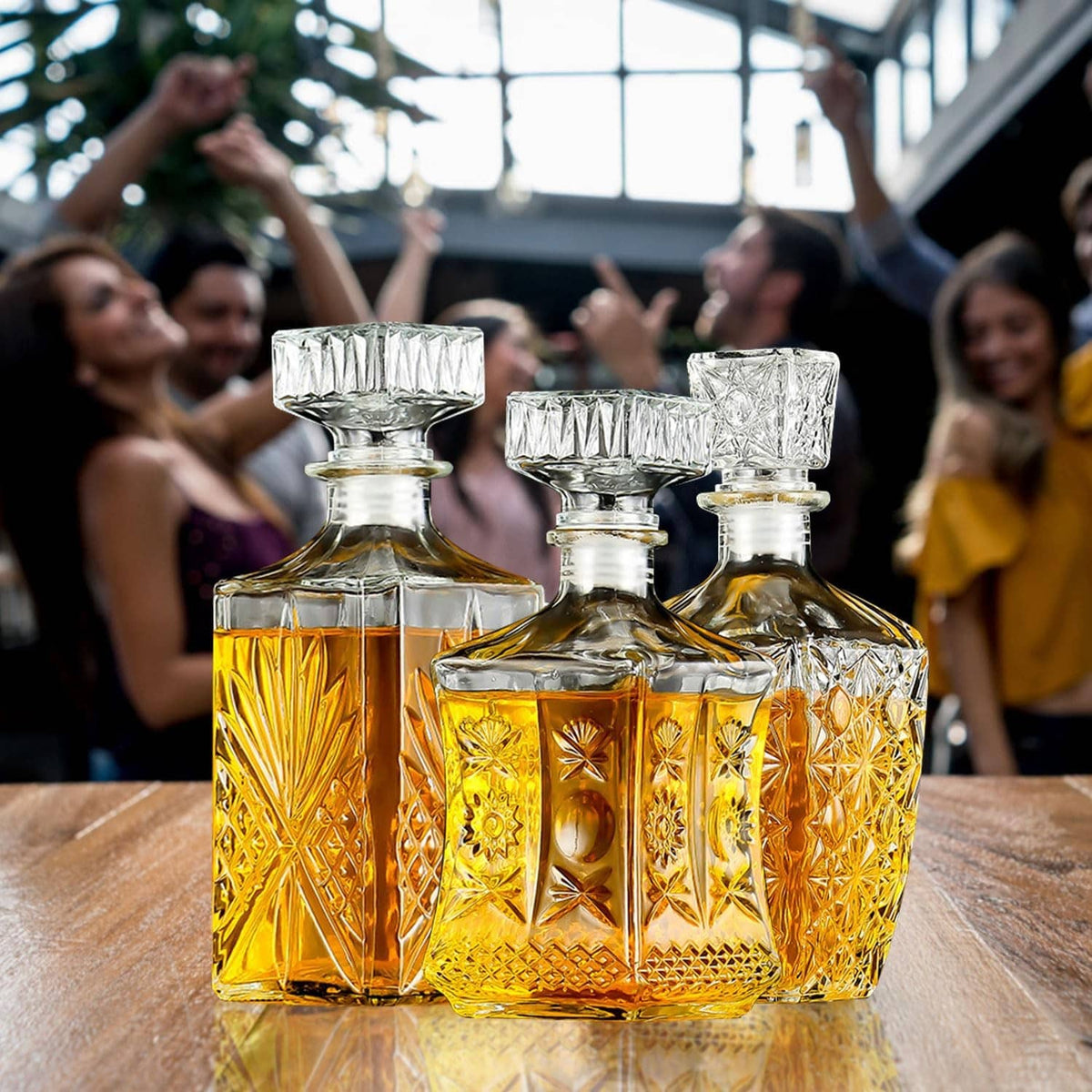 Three crystal whiskey decanters with faceted glass panels and clear, ribbed stoppers
