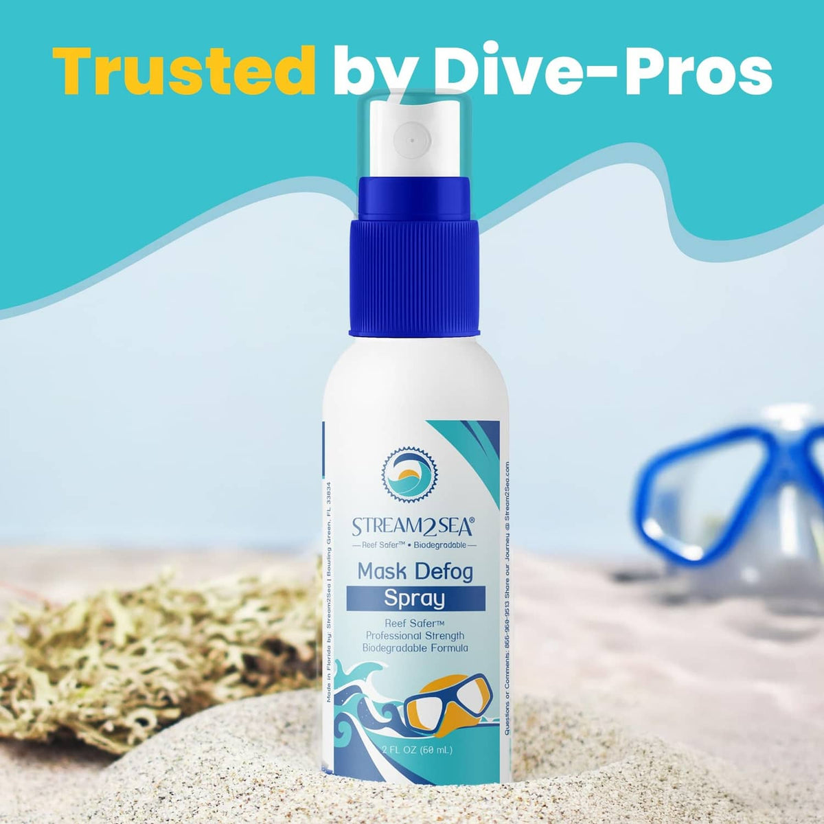 Mask defog spray bottle with blue cap on sandy beach