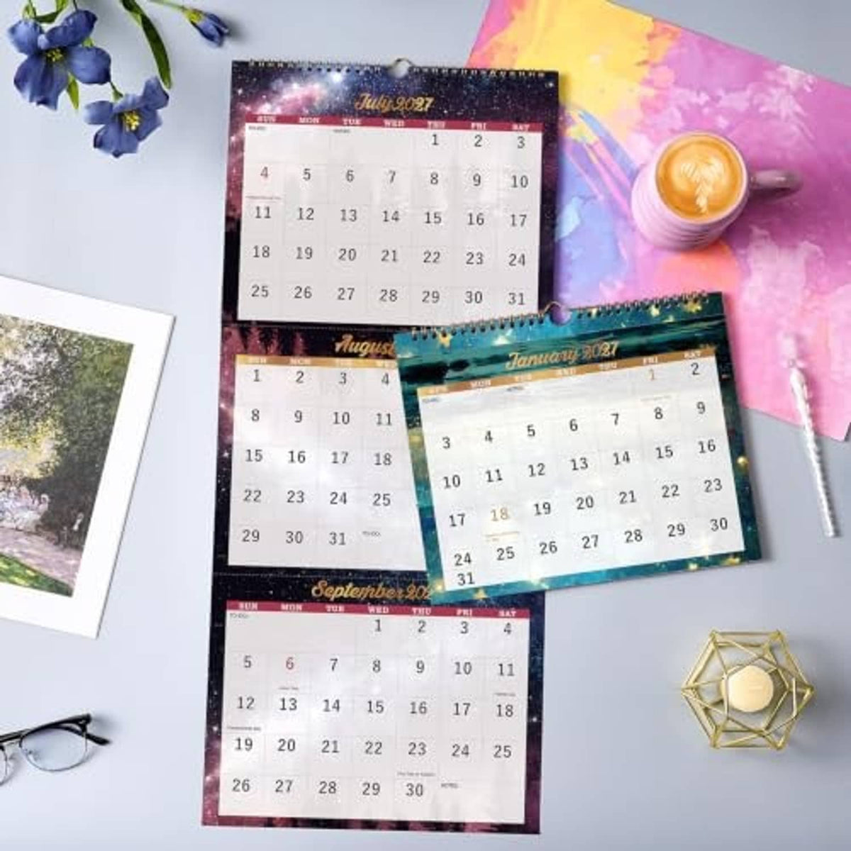Three-month calendars with colorful month panels laid out on a surface