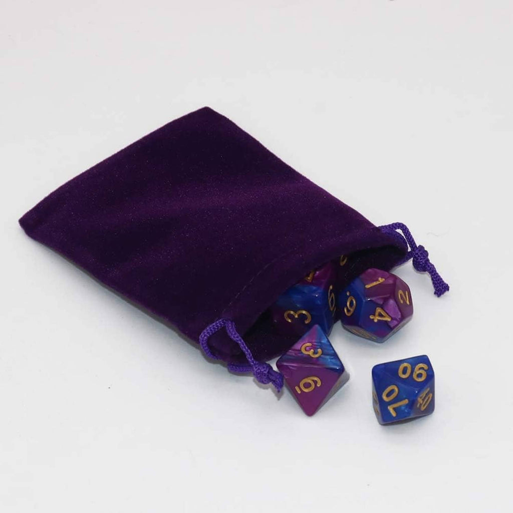 Purple velvet drawstring jewelry pouch with dice beside it