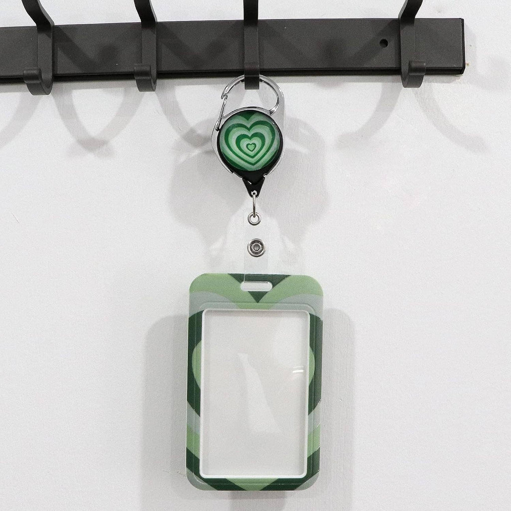 Green lanyard badge reel with clear ID sleeve and heart-pattern card front, empty