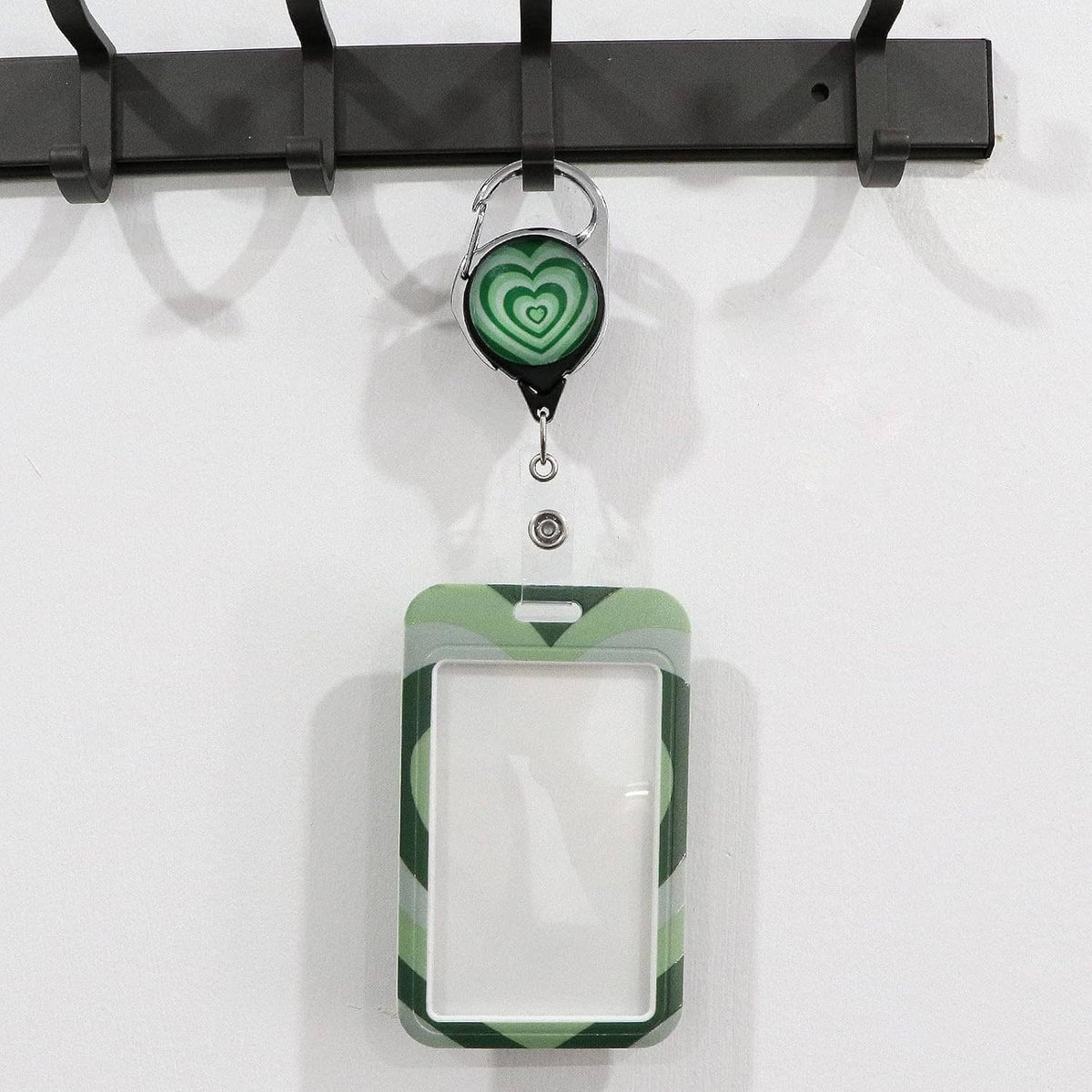Green lanyard badge reel with clear ID sleeve and heart-pattern card front, empty