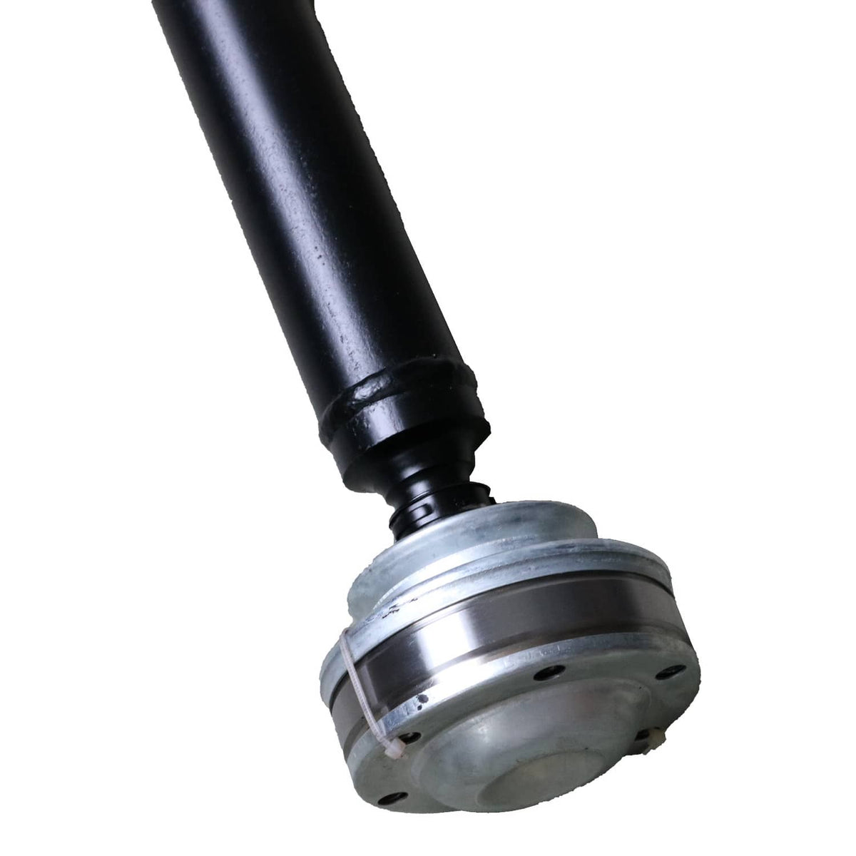 Close-up of front drive shaft joint: black tube with silver flange and rubber boot