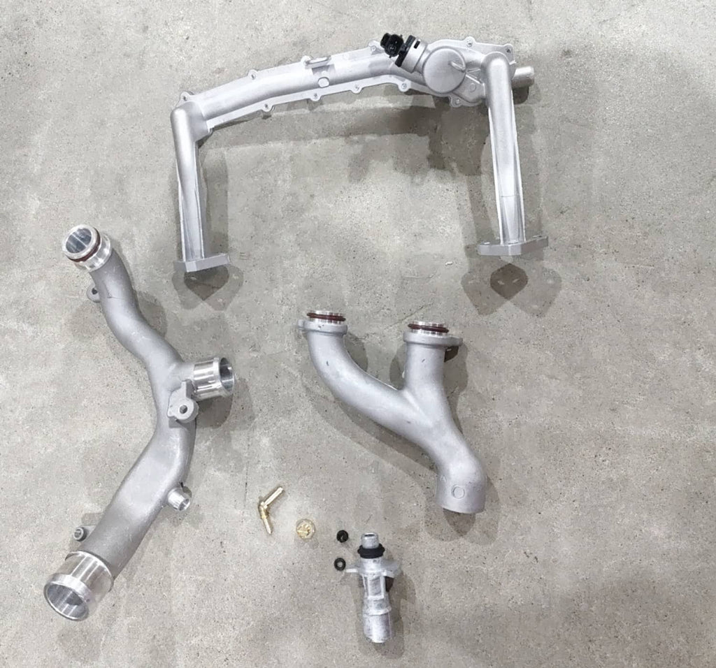 Assembled metal coolant pipe assembly with curved pipes and sensor ports