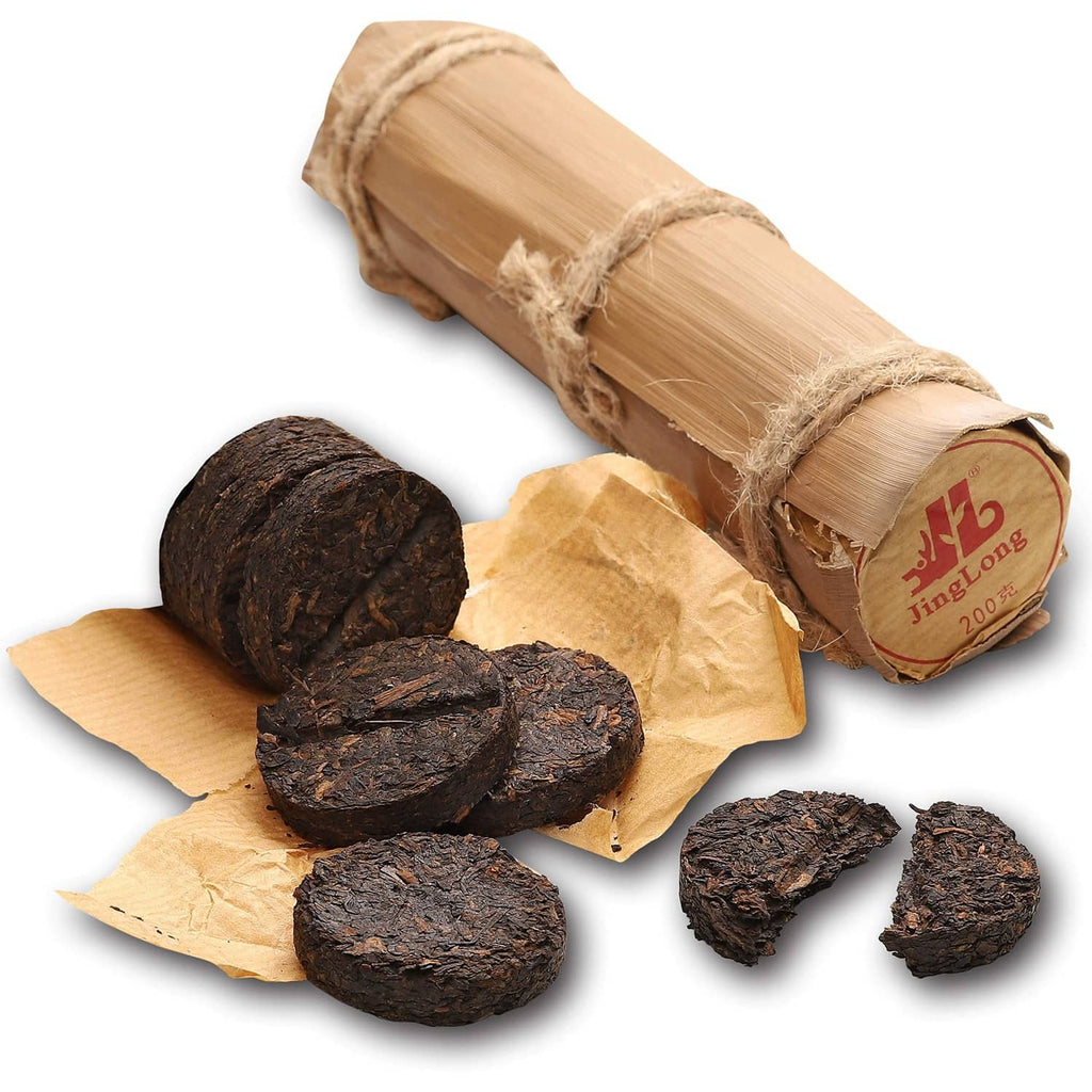 Ripe pu-erh tea in bamboo leaf tube with dark tea rounds and torn wrapper