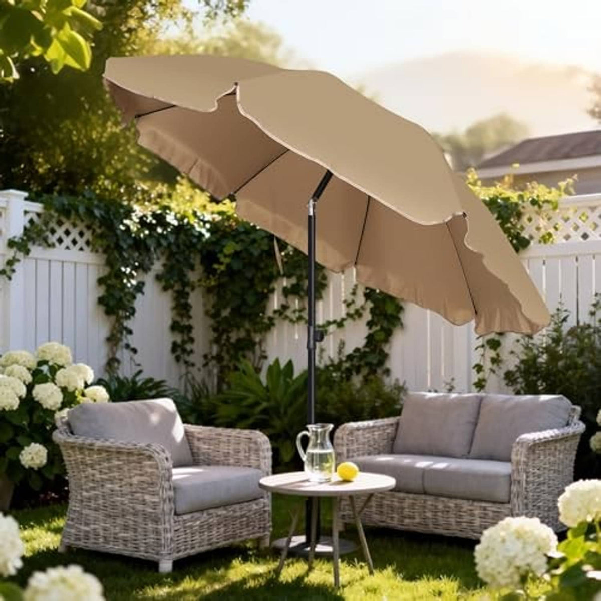 Tan patio umbrella open over wicker seating set on a backyard lawn