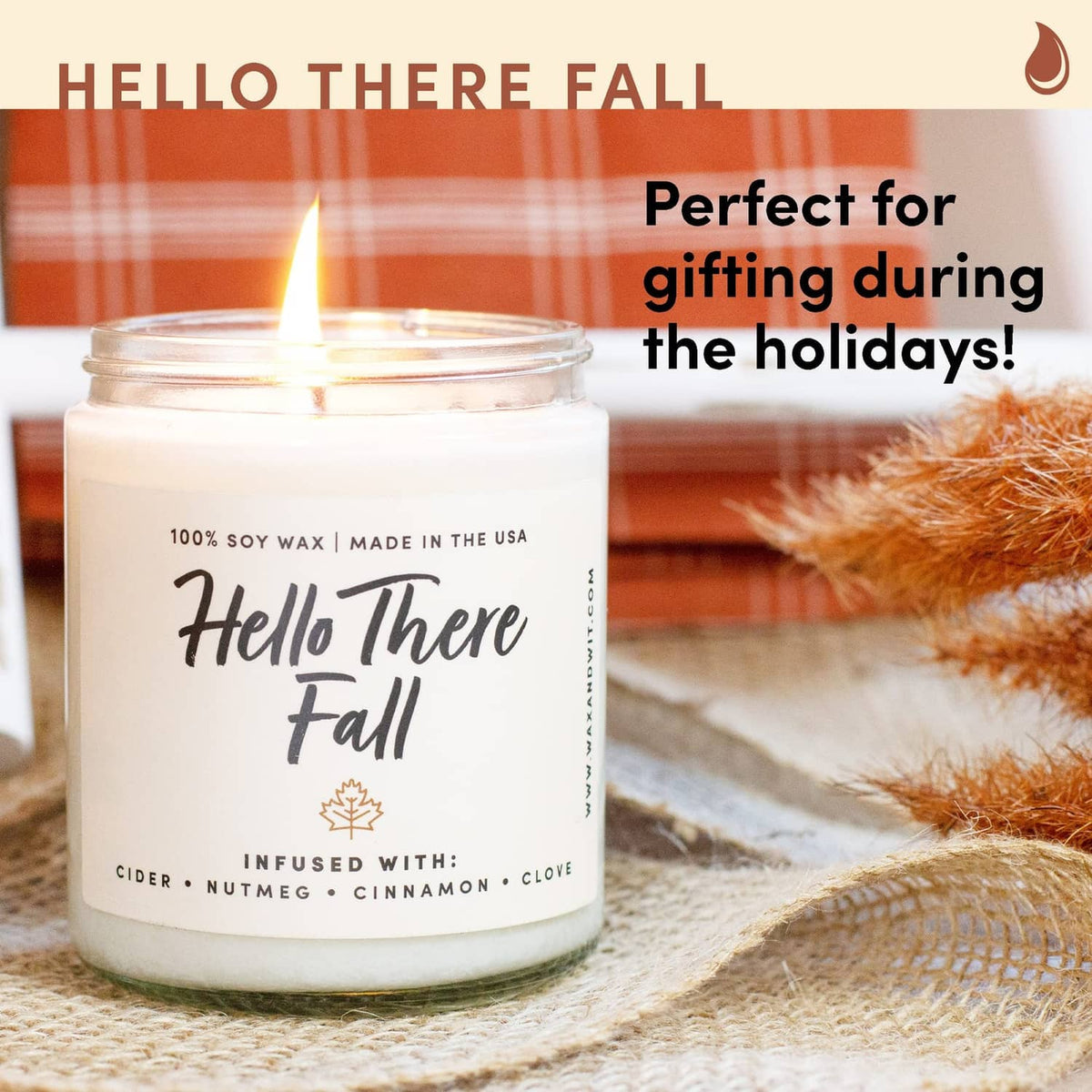 Scented soy candle jar with 'Hello There Fall' label and burning wick