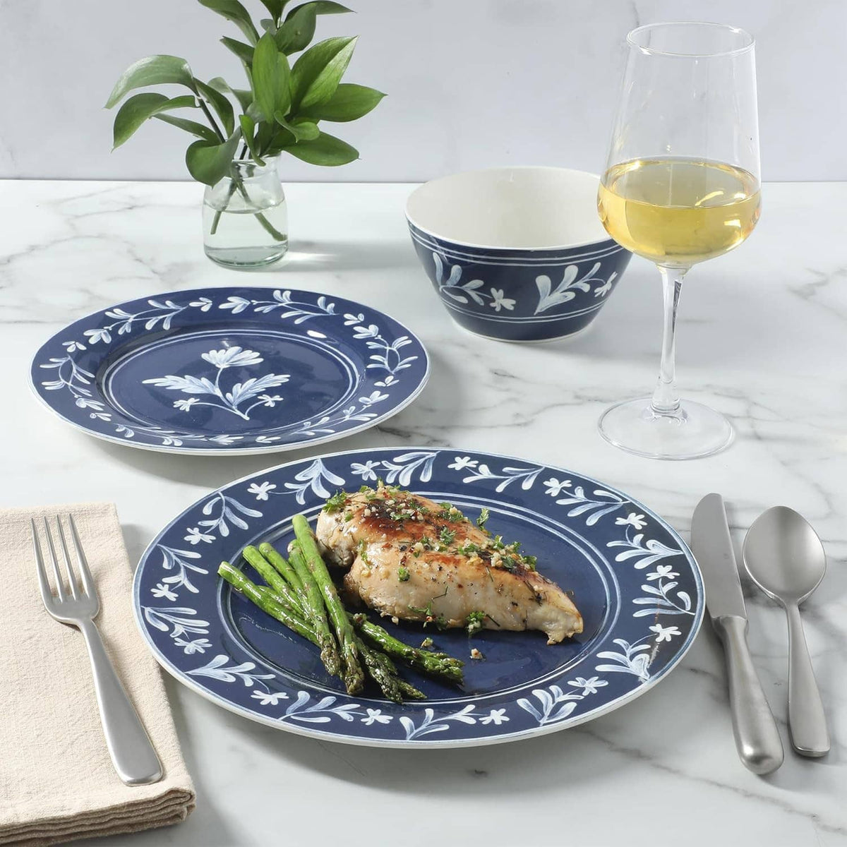 Dark blue floral dinnerware set with matching bowls, served plate with chicken and greens