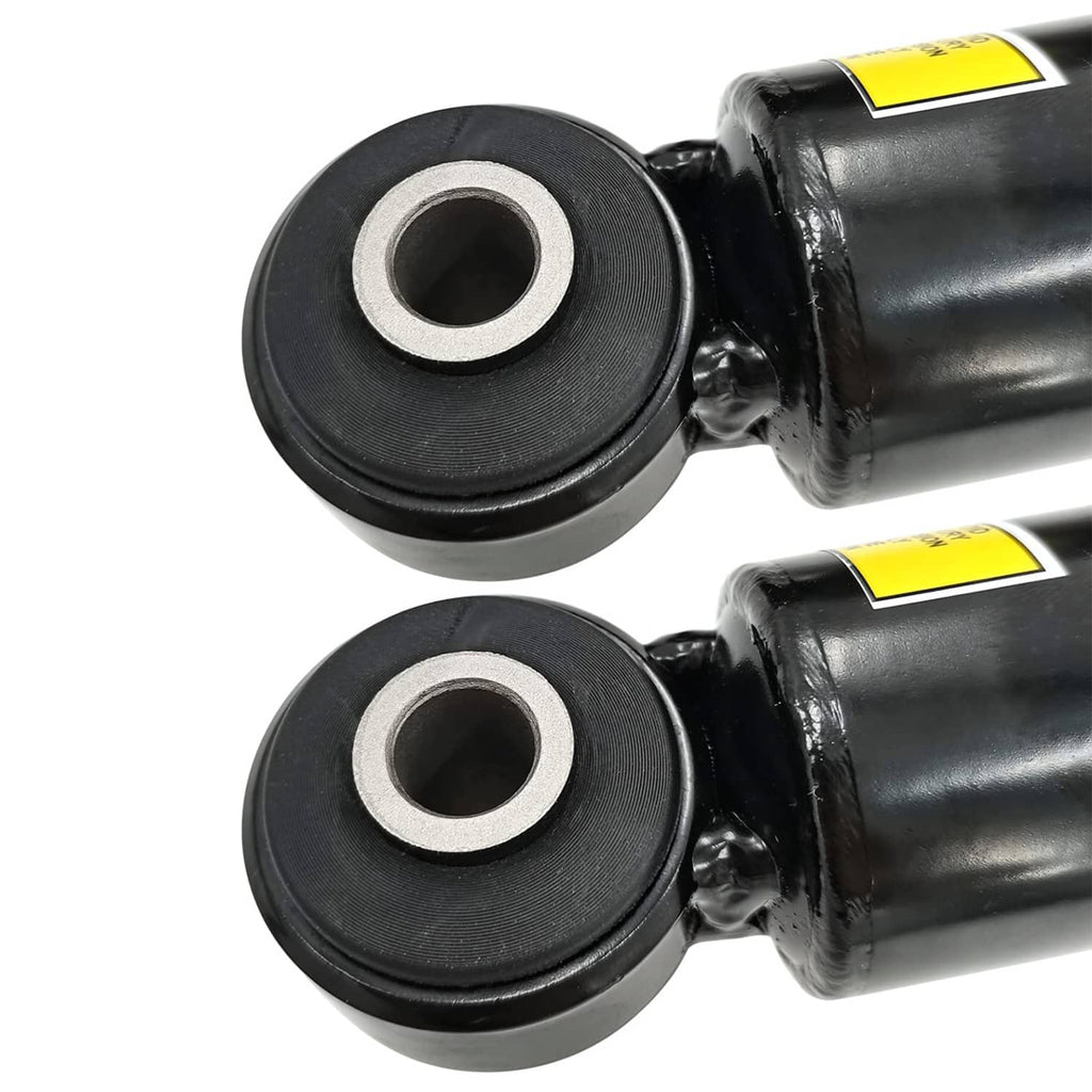 Two rubber mounting bushings with metal center on black shock absorber housings