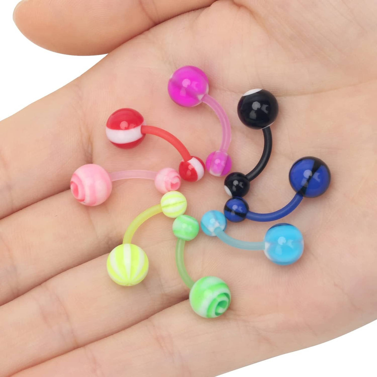 Assorted acrylic tongue rings on palm, colorful and black curved barbells