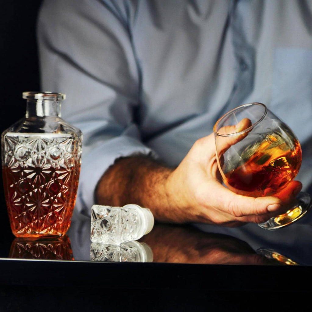 Faceted crystal whiskey decanters: one amber and one clear bottle with textured stoppers