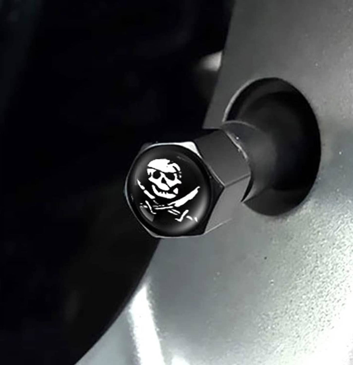 Close-up of black pirate skull valve stem cap with rubber sealing ring