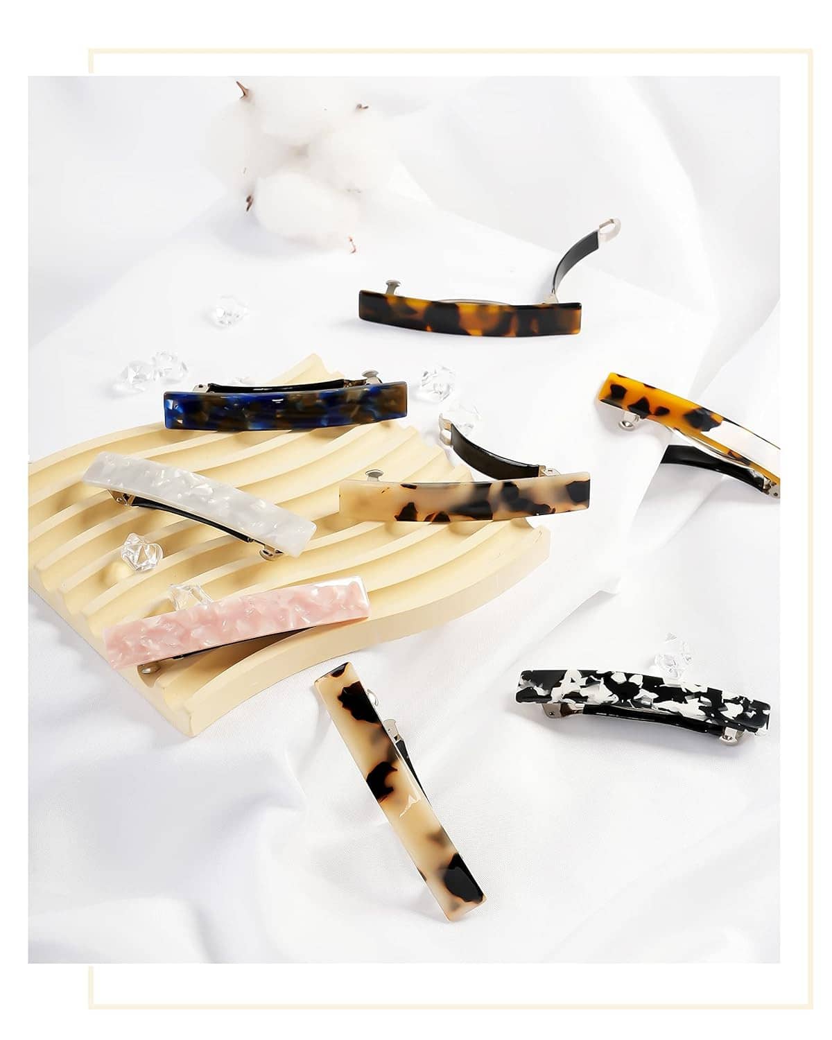 Assorted hair barrettes on a light background, featuring tortoiseshell, blue, pink, and clear.